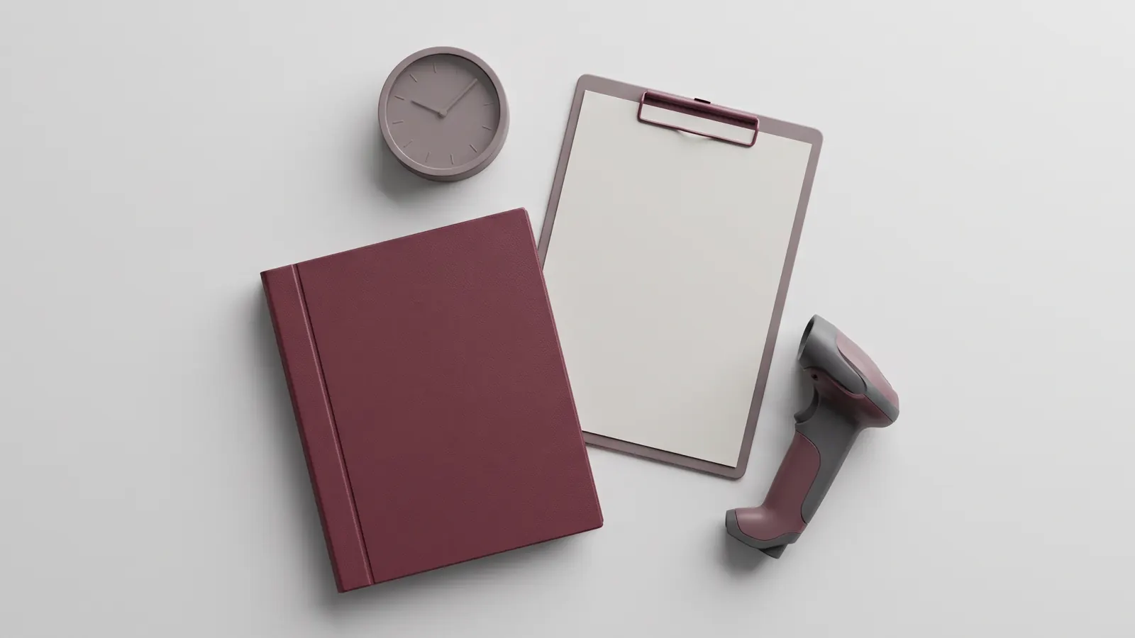 Overhead view of a desk clock, burgundy binder, blank clipboard and handheld scanner on a light grey desk